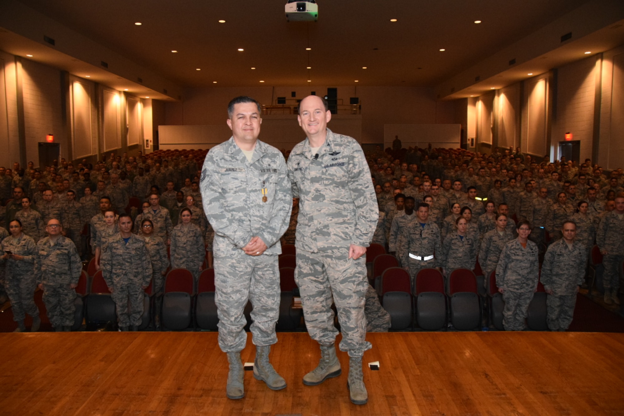 Col. Thomas K. Smith Jr., 433rd Airlift Wing commander, right, congratulates Tech. Sgt. Daniel Juarez, of the 433rd Aerospace Medicine Squadron, after presenting him the Air Force Commendation Medal during the 433rd AW commander's call April 3, 2016 at the Bob Hope Theater, Joint Base San Antonio-Lackland. (U.S. Air Force photo by Tech. Sgt. Carlos J. Trevino)