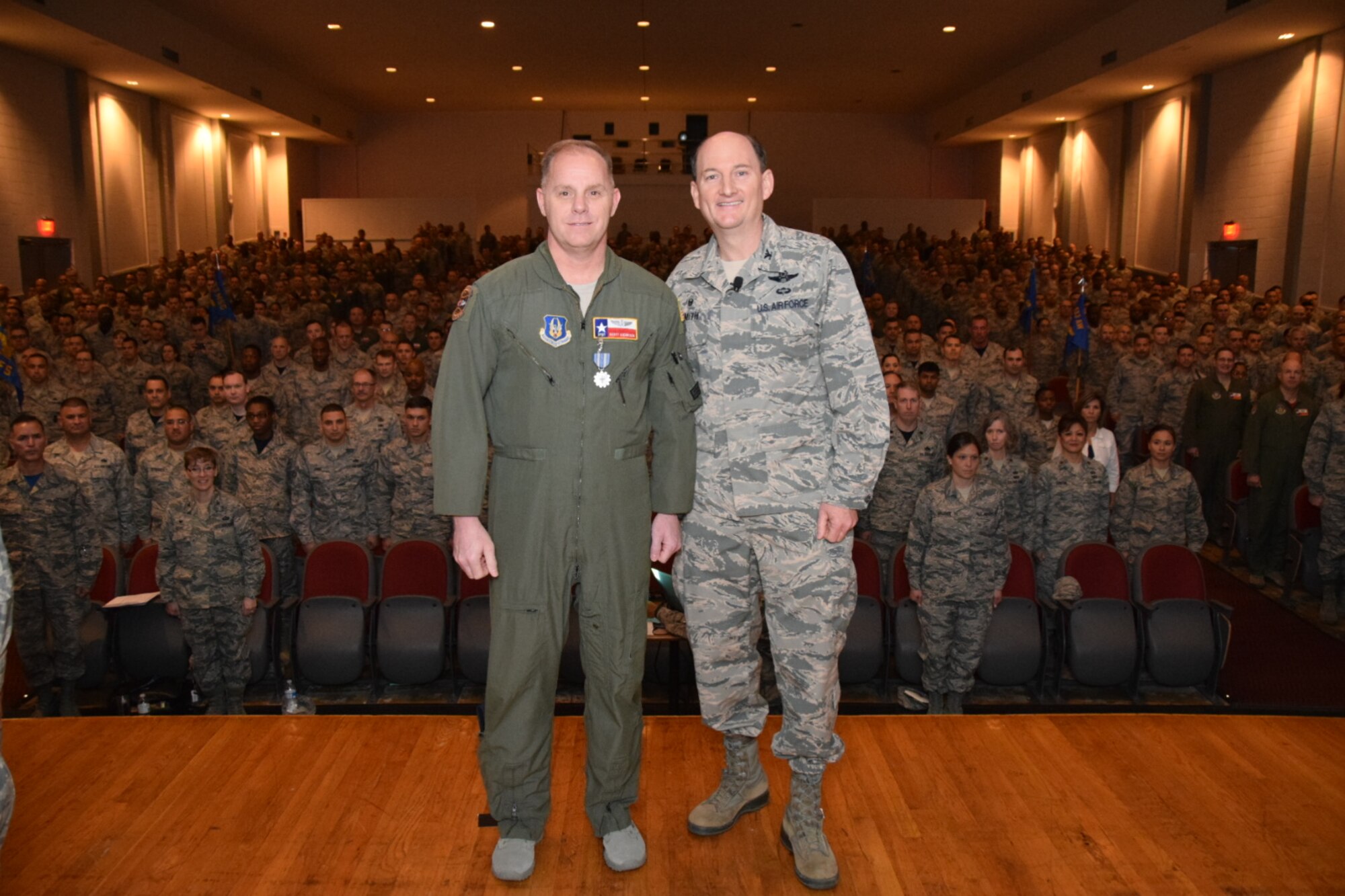 Col. Thomas K. Smith Jr., 433rd Airlift Wing commander, right, congratulates Tech. Sgt. Scott Anderson, of the 733rd Training Squadron, after presenting him the Air Force Achievement Medal during the 433rd AW commander's call April 3, 2016 at the Bob Hope Theater, Joint Base San Antonio-Lackland. (U.S. Air Force photo by Tech. Sgt. Carlos J. Trevino)
