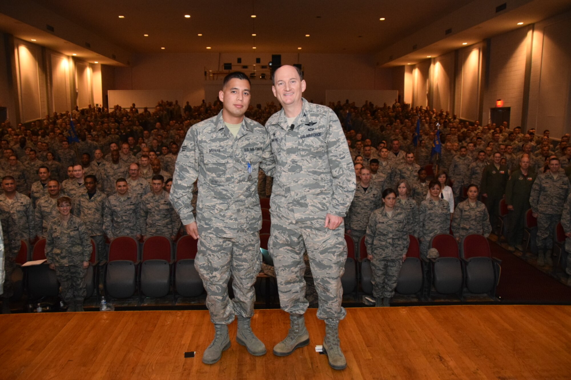 Col. Thomas K. Smith Jr., 433rd Airlift Wing commander, right, congratulates Senior Airman Juan Arenas Jr., of the 433rd Aeromedical Evacuation Squadron, after presenting him the Air Force Achievement Medal during the 433rd AW commander's call April 3, 2016 at the Bob Hope Theater, Joint Base San Antonio-Lackland. (U.S. Air Force photo by Tech. Sgt. Carlos J. Trevino)