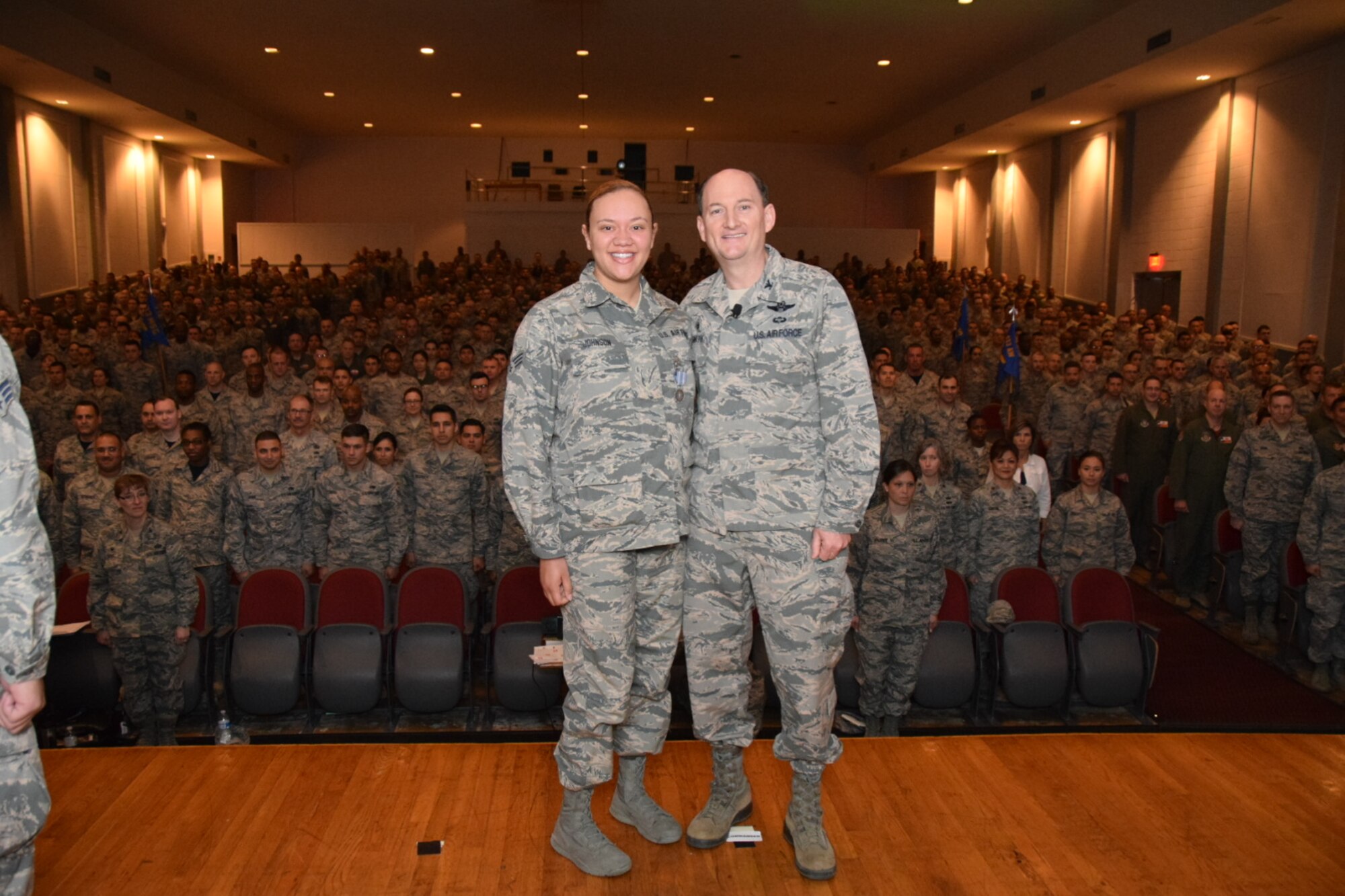 Col. Thomas K. Smith Jr., 433rd Airlift Wing commander, right, congratulates Senior Airman Peyton Johnson, of the 433rd Aerospace Medicine Squadron, after presenting her  the Air Force Achievement Medal during the 433rd AW commander's call April 3, 2016 at the Bob Hope Theater, Joint Base San Antonio-Lackland. (U.S. Air Force photo by Tech. Sgt. Carlos J. Trevino)