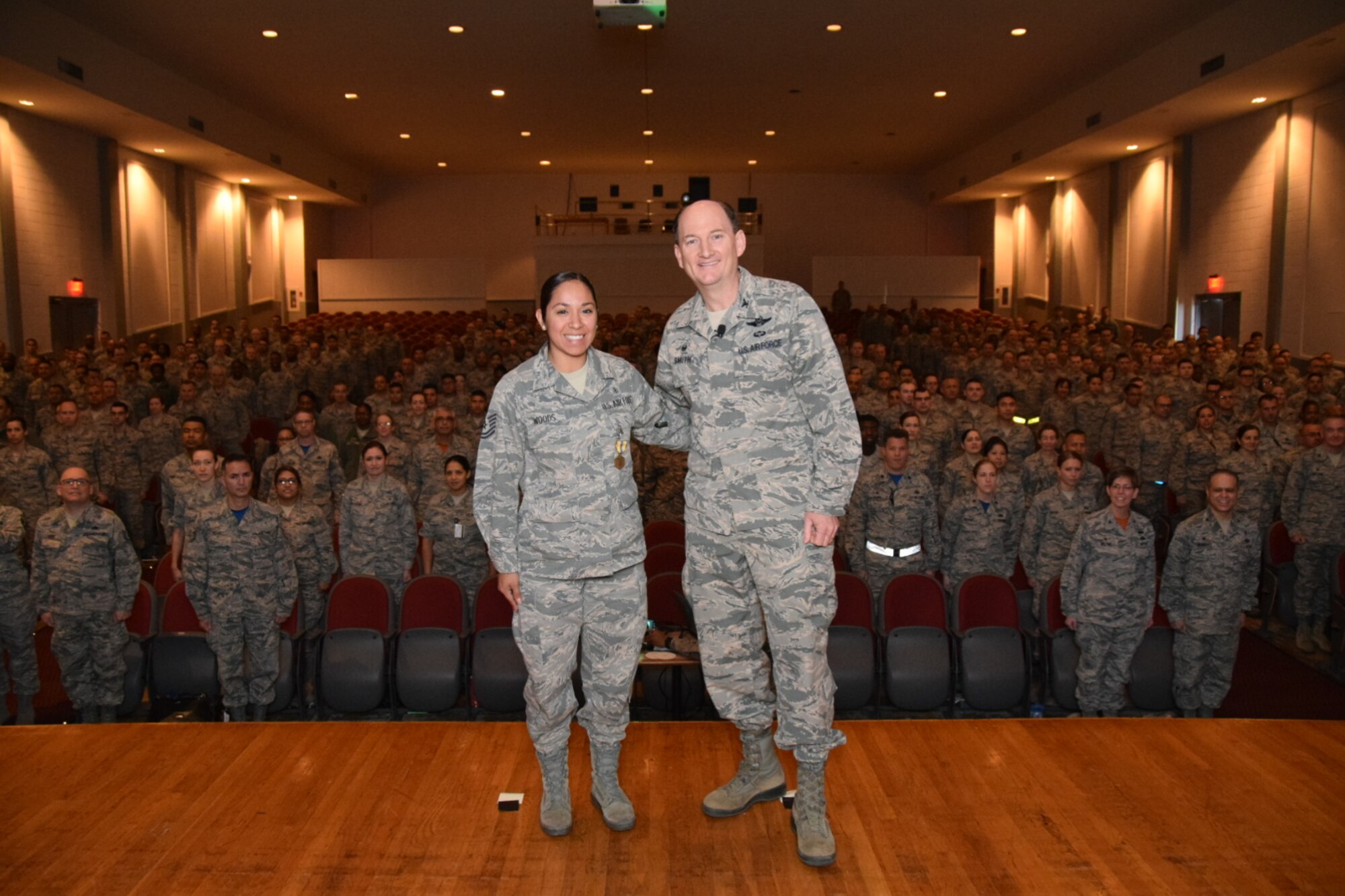 Col. Thomas K. Smith Jr., 433rd Airlift Wing commander, right, congratulates Tech. Sgt. Anna Woods, of the 433rd Aerospace Medicine Squadron, after presenting her with the Air Force Commendation Medal during the 433rd AW commander's call April 3, 2016 at the Bob Hope Theater, Joint Base San Antonio-Lackland. (U.S. Air Force photo by Tech. Sgt. Carlos J. Trevino)