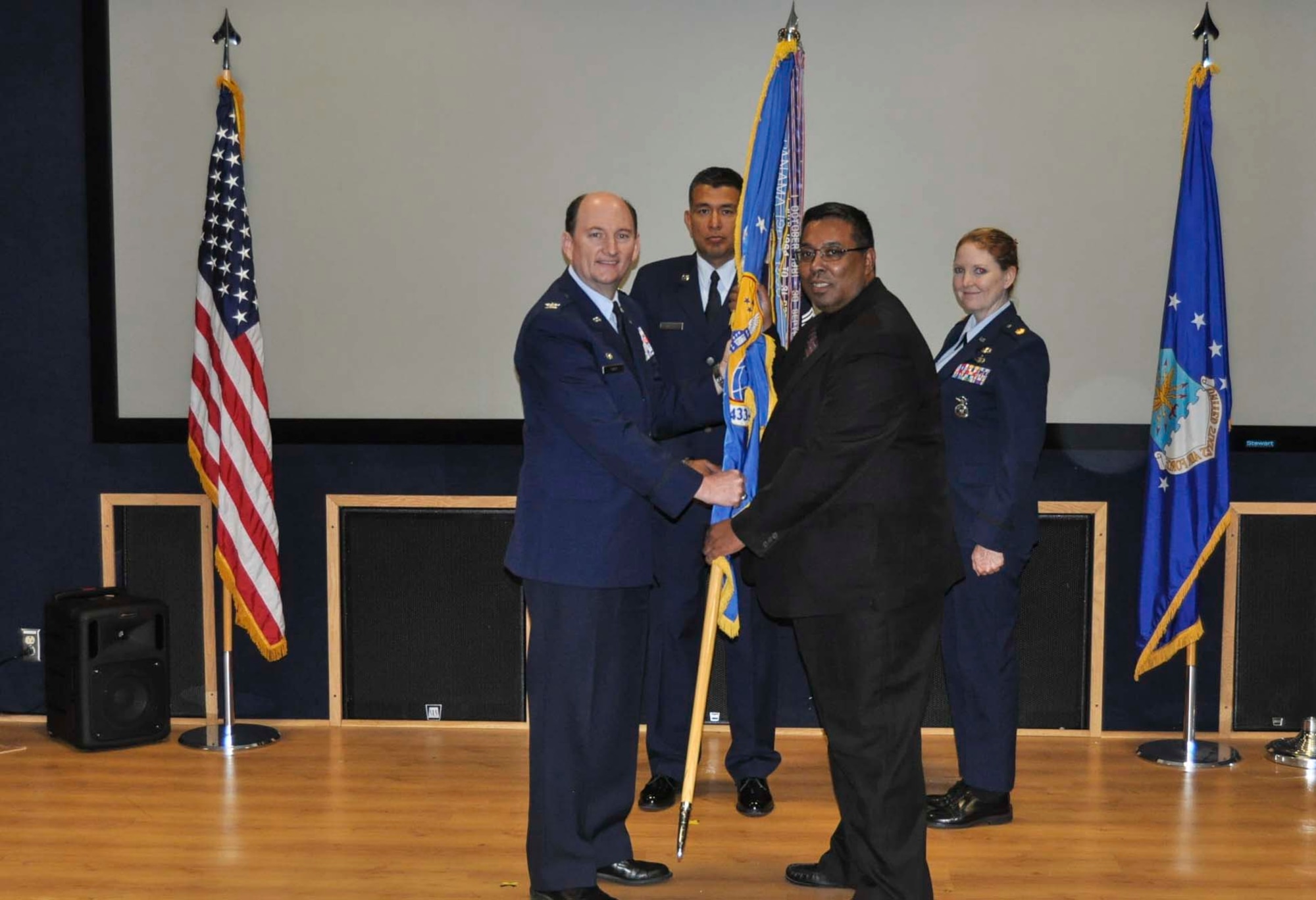 John Smith accepts the 433rd Airlift Wing guidon from Col. Thomas K. Smith, Jr., 433rd AW commander, during the Honorary Commanders Induction Ceremony held at Joint Base San Antonio-Lackland April 30, 2016. Smith is currently a general attorney for the Department of Homeland Security and will be serving as the 433rd Security Forces Squadron Honorary Commander. (U.S. Air Force photo/Senior Airman Bryan Swink)