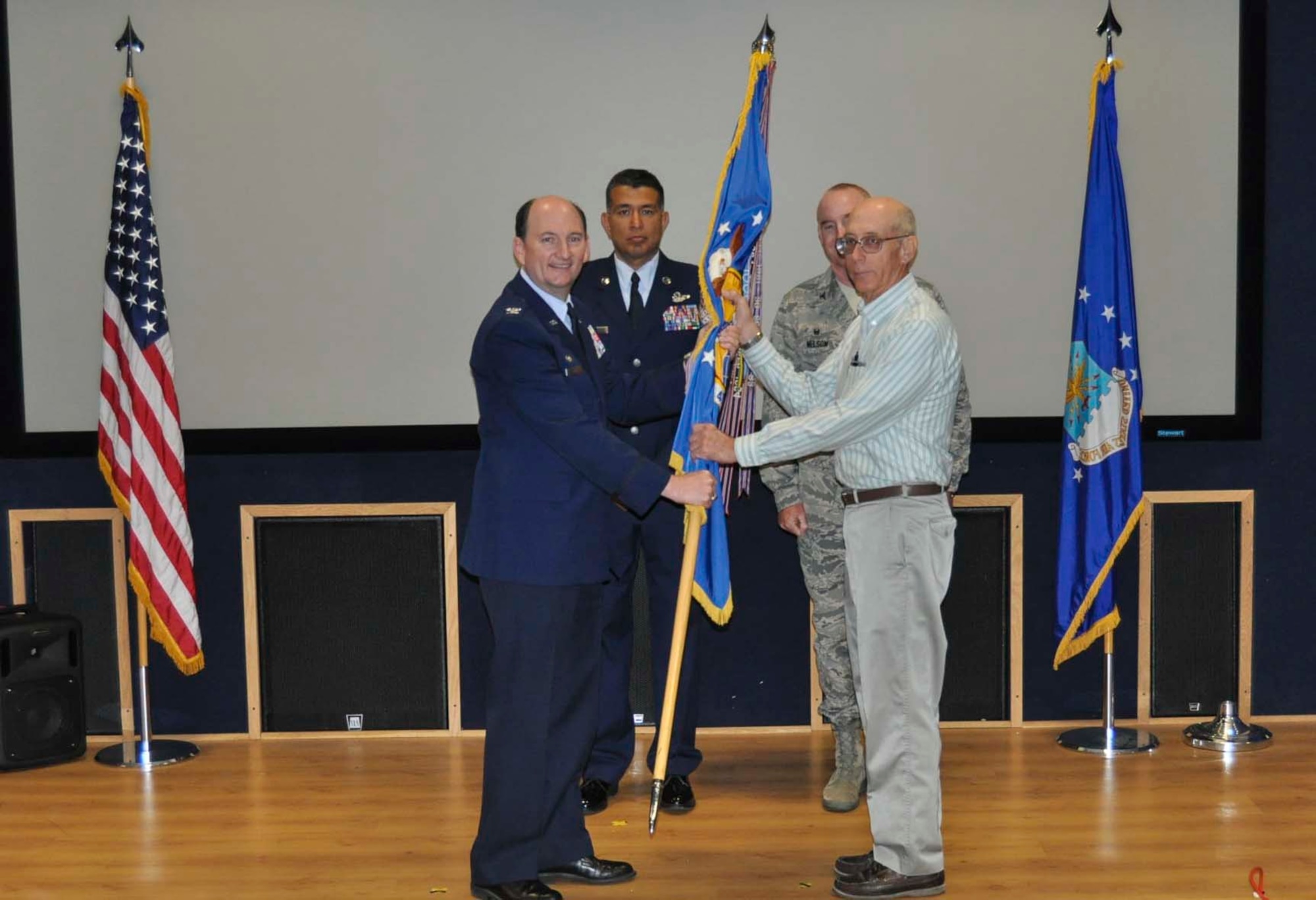 Arnold Dollase accepts the 433rd Airlift Wing guidon from Col. Thomas K. Smith, Jr., 433rd AW commander, during the Honorary Commanders Induction Ceremony held at Joint Base San Antonio-Lackland April 30, 2016. Dollase is the president of the Castroville Area Economic Development Council and will be serving as the 433rd Medical Squadron Honorary Commander. (U.S. Air Force photo/Senior Airman Bryan Swink)