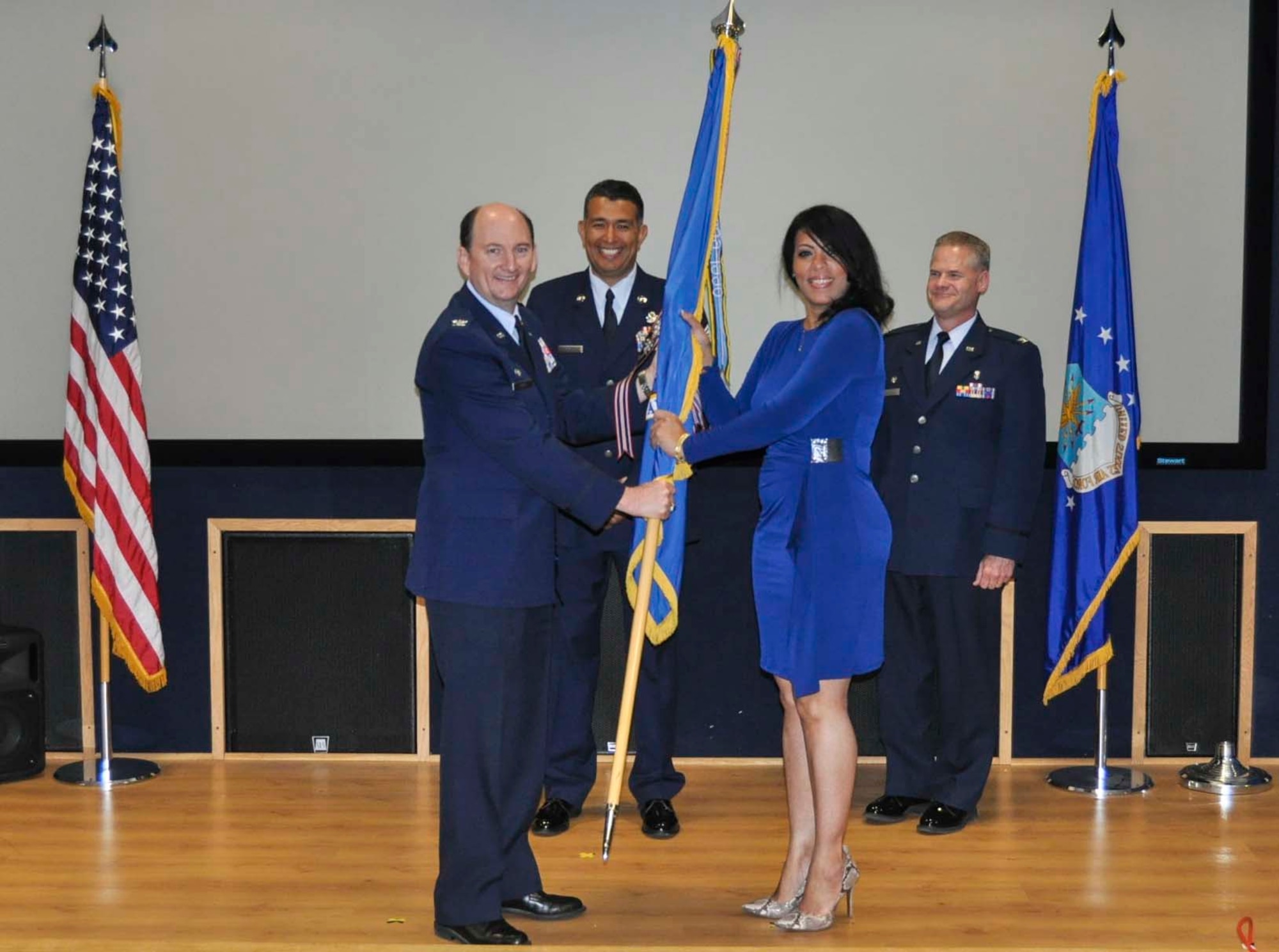 Belkis Lane accepts the 433rd Airlift Wing guidon from Col. Thomas K. Smith, Jr., 433rd AW commander, during the Honorary Commanders Induction Ceremony held at Joint Base San Antonio-Lackland April 30, 2016. Lane currently serves as the chief executive officer for The Restaurant Fanatic and will be serving as the 433rd Aeromedical Staging Squadron Honorary Commander. (U.S. Air Force photo/Senior Airman Bryan Swink)