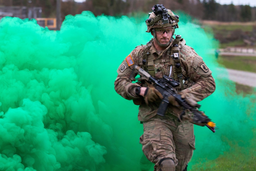 A soldier moves under the cover of smoke while participating in exercise Saber Junction 16 in Grafenwoehr, Germany, April 18, 2016. Army photo by Pfc. Randy Wren