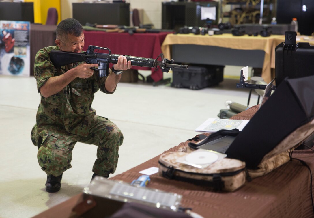 A Japan Ground Self-Defense Force member visiting the annual Training Expo on Camp Hansen, Okinawa, Japan, tests out the Instrumental Tactical Evaluation Simulated System, April 29, 2016. This recently updated system works almost like the popular game, "laser tag," where a laptop traces the marksmanship of the shooter. This training can be recorded and handed back to the unit on a CD to evaluate performance. (U.S. Marine photo by LCpl. Amaia Unanue/Released)