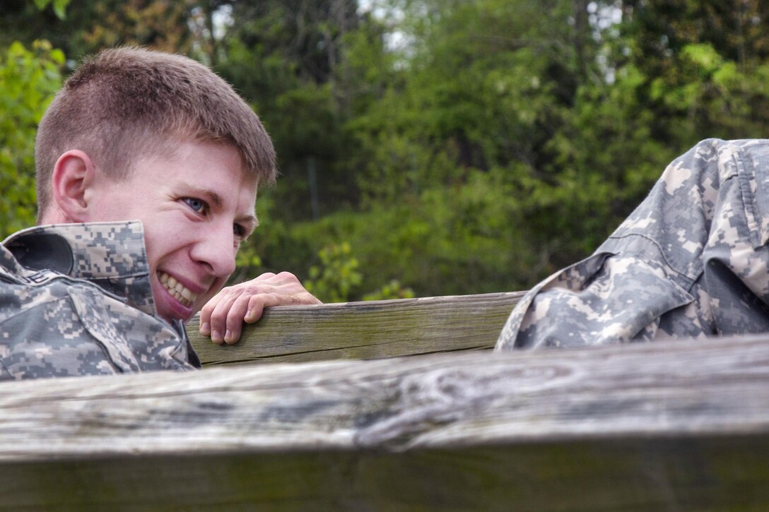 Army Staff Sgt. Michael Huettel pulls himself over a wooden beam obstacle during the Ordnance Group Team of the Year 2016 competition at the Wendell H. Ford Regional Training Center in Greenville, Ky., April 25, 2016. Huettel is assigned to the Alabama National Guard’s 641st Ordnance Company, 441st Ordnance Battalion. Army photo by Pfc. Aaron Bratcher