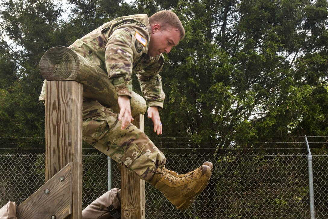 Army Staff Sgt. Kenneth Dollar pulls himself over a log obstacle during the Ordnance Group Team of the Year 2016 competition at the Wendell H. Ford Regional Training Center in Greenville, Ky., April 25, 2016. Dollar is assigned to the Alabama National Guard’s 666th Ordnance Company, 441st Ordnance Battalion. Army photo by Pfc. Aaron Bratcher