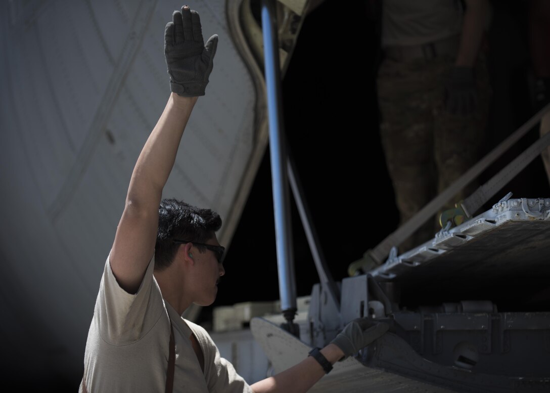 Senior Airman Chris Arnold, 774th Expeditionary Airlift Squadron loadmaster, directs a forklift with cargo to be placed onto the ramp of a C-130J Super Hercules at Bagram Airfield, Afghanistan, April 29, 2016. Loadmasters ensure cargo and personell are loaded properly for flight. (U.S. Air Force photo by Senior Airman Justyn M. Freeman)