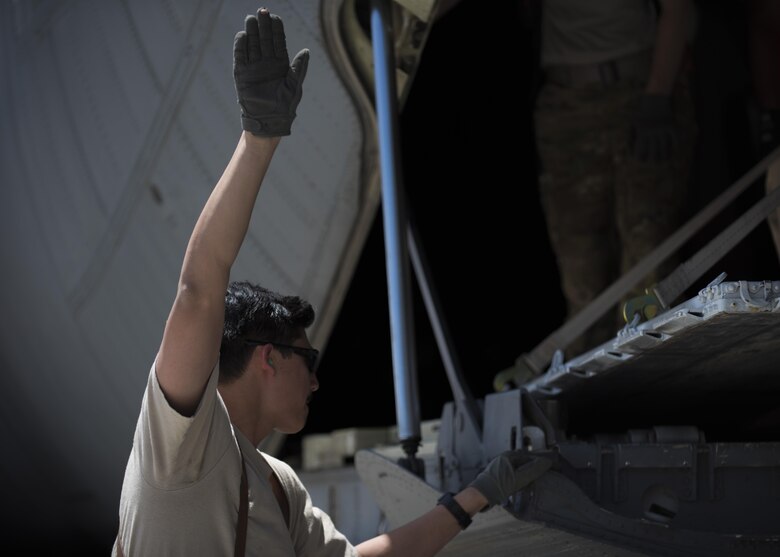 Senior Airman Chris Arnold, 774th Expeditionary Airlift Squadron loadmaster, directs a forklift with cargo to be placed onto the ramp of a C-130J Super Hercules at Bagram Airfield, Afghanistan, April 29, 2016. Loadmasters ensure cargo and personell are loaded properly for flight. (U.S. Air Force photo by Senior Airman Justyn M. Freeman)