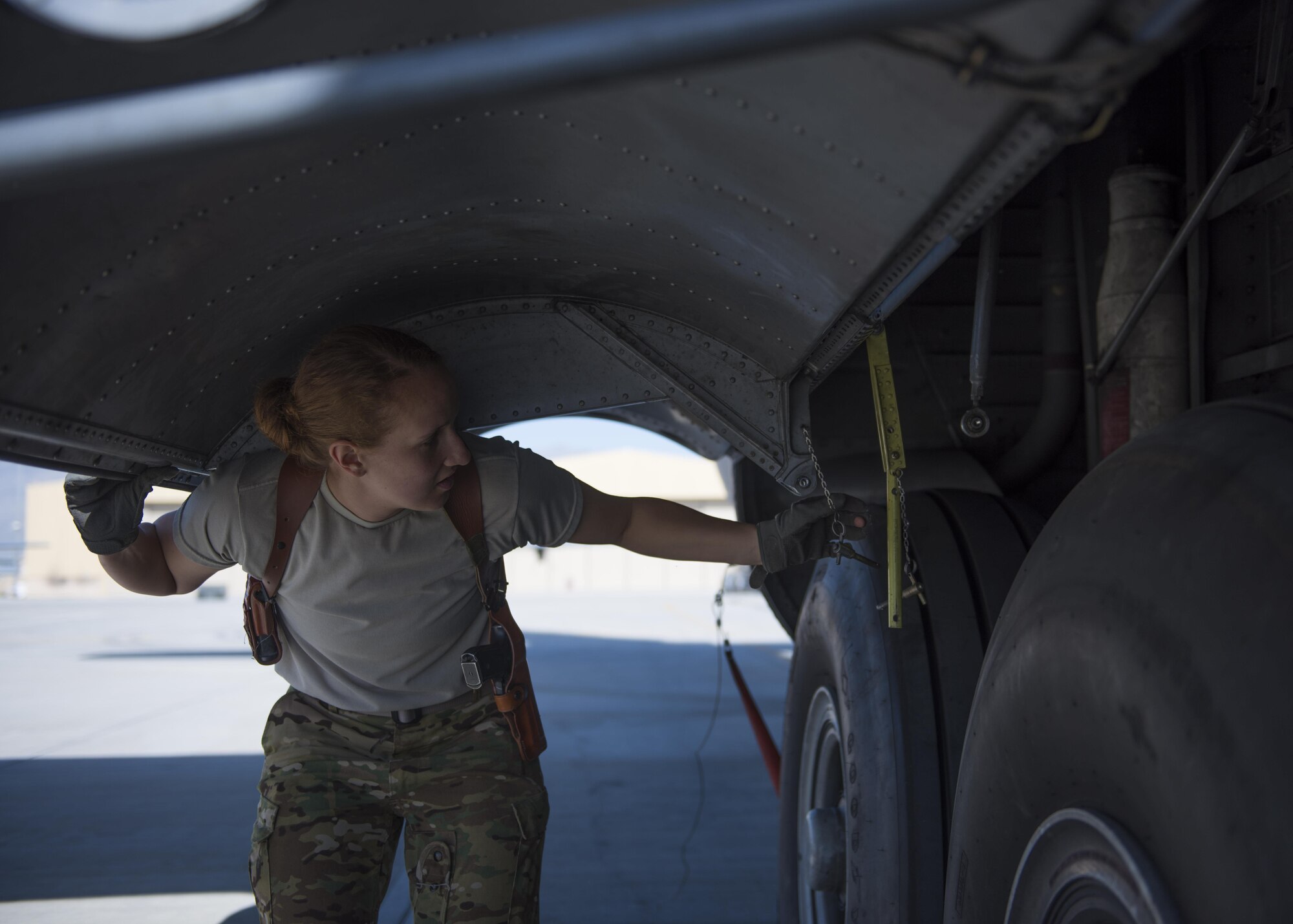 Senior Airman Jessica Jones, 774th Expeditionary Airlift Squadron loadmaster, lifts up the landing gear cover during a pre-flight inspection of a C-130J Super Hercules at Bagram Airfield, Afghanistan, April 29, 2016. As a loadmaster, Jones is responsible for ensuring the aircraft is ready for flight. (U.S. Air Force photo by Senior Airman Justyn M. Freeman)