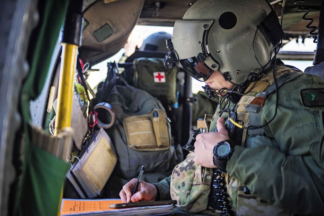 An Air Force crew chief reads over the mission order before participating in a simulated casualty evacuation training exercise off the coast of Homer, Alaska, April 27, 2016. The scenario involved an injured member of a fishing vessel who required immediate treatment and extraction from the boat. The airman is assigned to the Alaska Air National Guard. Alaska National Guard photo by Air Force Staff Sgt. Edward Eagerton