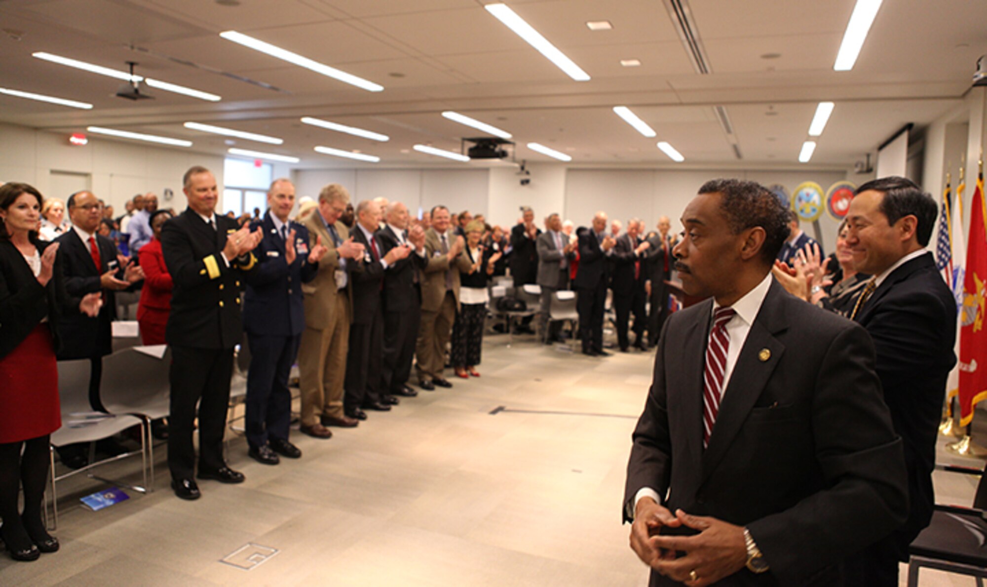 Senior military medical leaders and staff of the Military Health System stand to applaud Dr. Jonathan Woodson, who is stepping down as assistant secretary of Defense for Health Affairs after nearly six years of service. (Courtesy Photo)