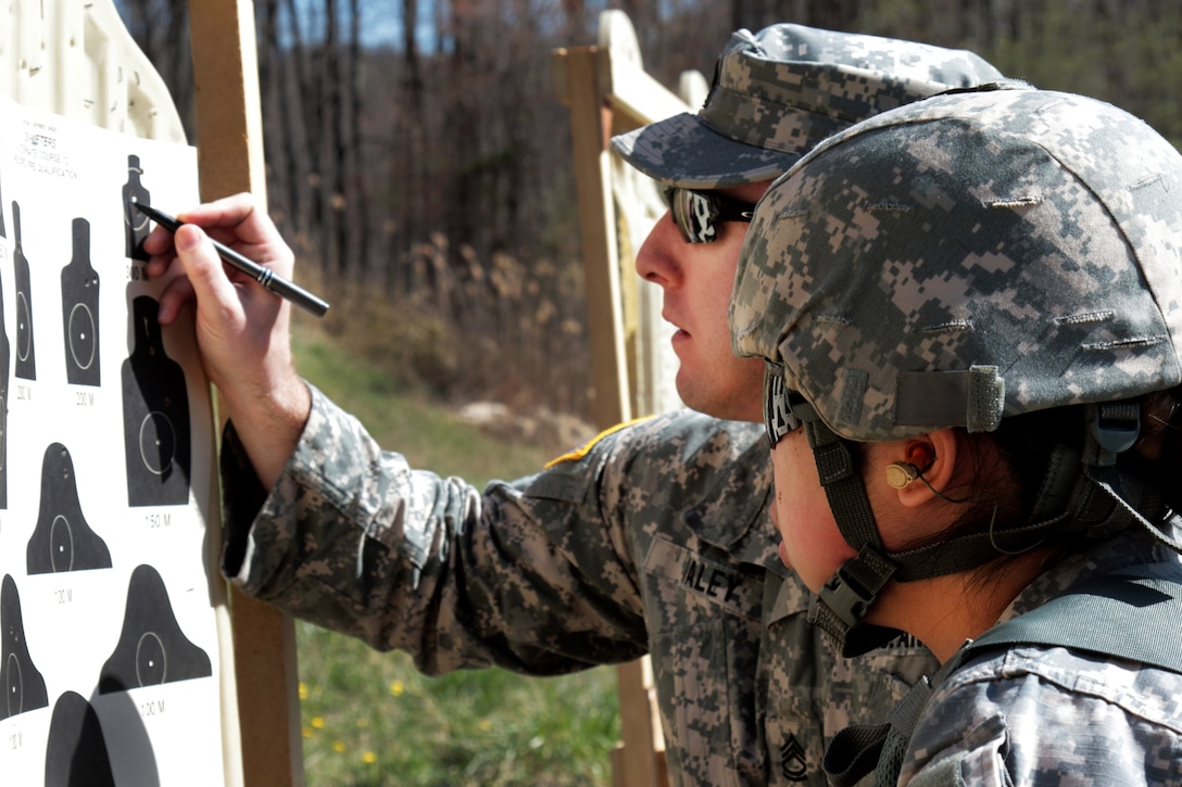Army Spc. Quan Han, right, reviews her paper target with Sgt. 1st Class Patrick Kaley during the weapons qualification event of the Best Warrior Competition at Camp Smith Training Site near Peekskill, N.Y., April 21, 2016. Han is an interior electrician assigned to the New York Army National Guard’s 1156th Engineer Company. Kaley is a range safety officer. New York National Guard photo by Army Sgt. Michael Davis
