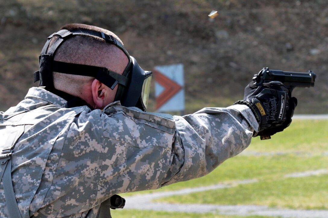 Army Spc. Dylan Lunde fires a 9 mm pistol while wearing a gas mask during the stress shoot event of the Best Warrior Competition at Camp Smith Training Site near Peekskill, N.Y., April 21, 2016. Lunde is a team chief assigned to the New York Army National Guard’s 1st Battalion, 258th Field Artillery Regiment. New York National Guard photo by Army Sgt. Michael Davis