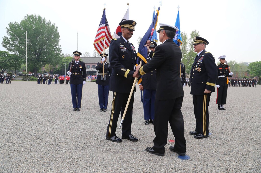 Army Gen. Vincent K. Brooks, incoming commander of U.S. Forces Korea, takes the command colors from Navy Adm. Harry B. Harris Jr., commander of U.S. Pacific Command, during a change-of-command ceremony at Yongsan Garrison, South Korea, April 30, 2016. Army photo by Sgt. Russell Youmans