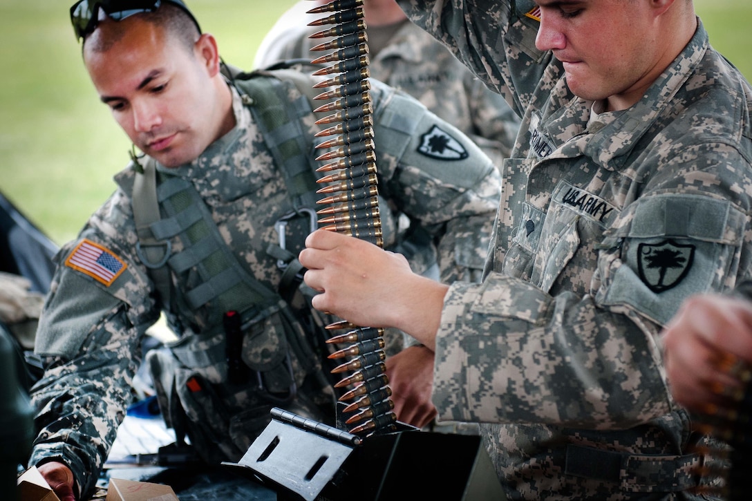 Soldiers prepare belts of ammo to be used on a UH-60 Black Hawk helicopter during a weapon qualification and gunnery training at Poinsett Range in Wedgefield, S.C., April 21, 2016. South Carolina National Guard photo by Army Staff Sgt. Roberto Di Giovine