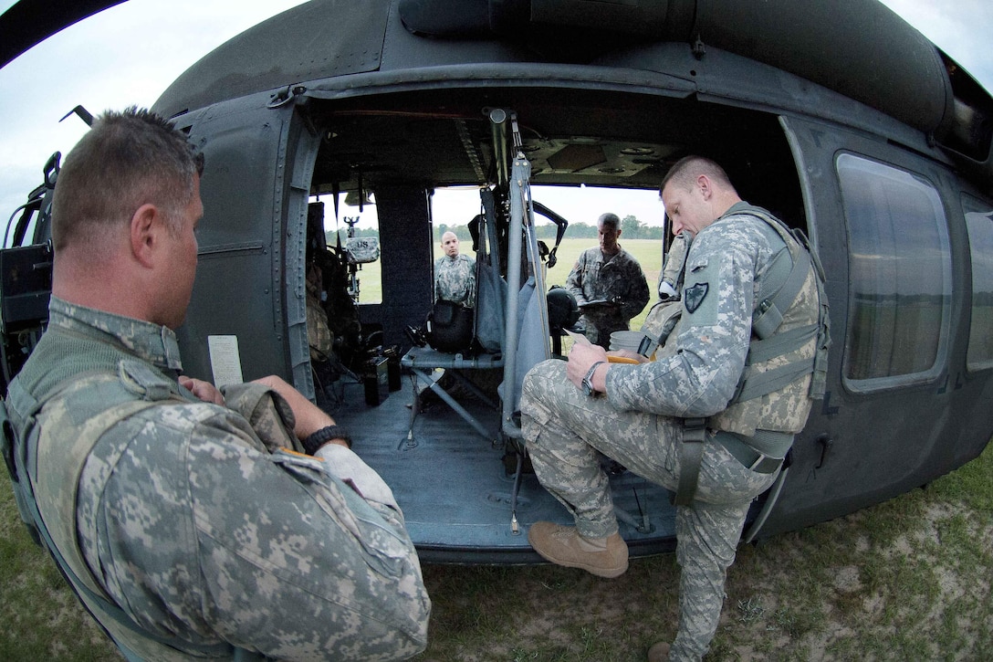 Army pilots and crew chiefs receive a mission and safety briefing before participating in qualification and gunnery training at Poinsett Range in Wedgefield, S.C., April 21, 2016. South Carolina National Guard photo by Army Staff Sgt. Roberto Di Giovine