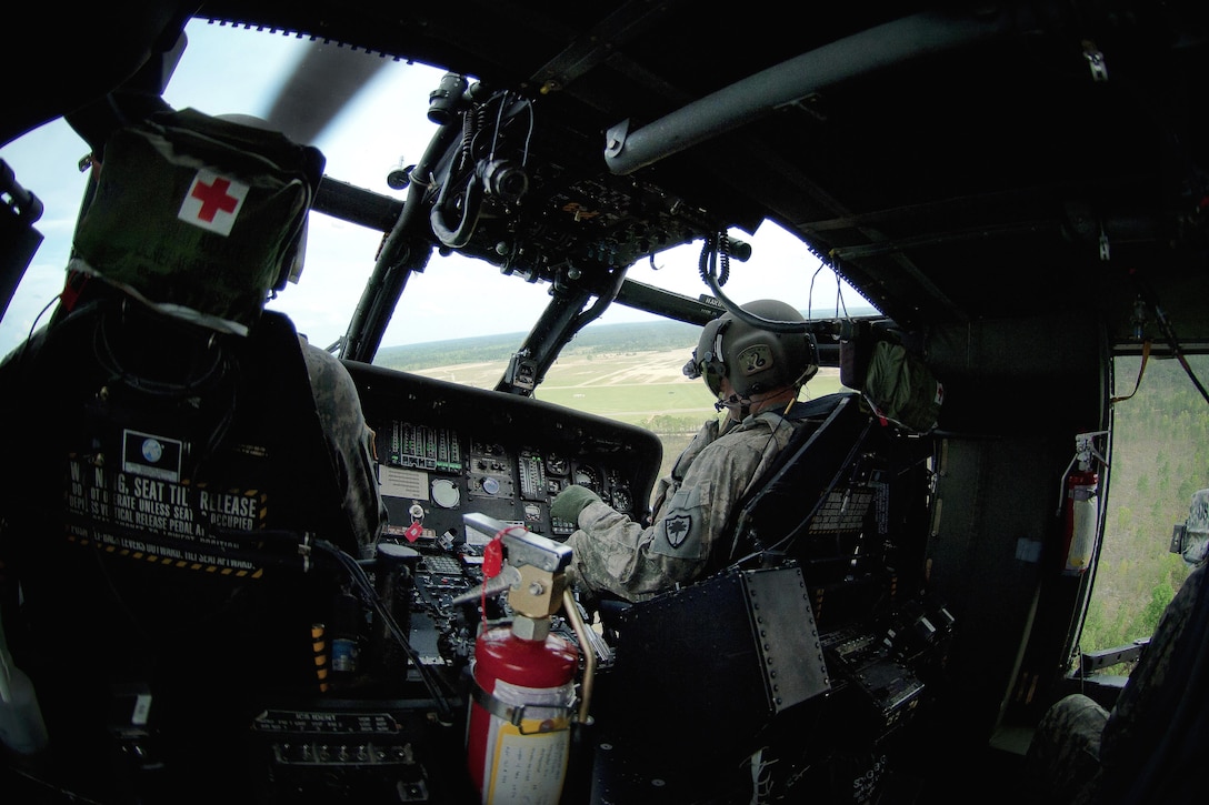 Army pilots fly a UH-60 Black Hawk helicopter during weapon qualification and gunnery training at Poinsett Range in Wedgefield, S.C., April 21, 2016. South Carolina National Guard photo by Army Staff Sgt. Roberto Di Giovine