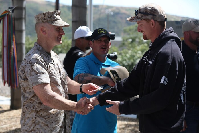 MARINE CORPS BASE CAMP PENDLETON, Calif. – Cpl. Ryan Provasi accepts a challenge coin from Col. Jason Morris at the 3rd Battalion, 5th Marine Regiment “Dark Horse” Reunion at the San Mateo Memorial Garden April 29, 2016. Provasi served as a rifleman with Company K during the battalion’s deployment to Sangin, Afghanistan in the fall of 2010. (U.S. Marine Corps photo by Lance Cpl. Shellie Hall/Released)