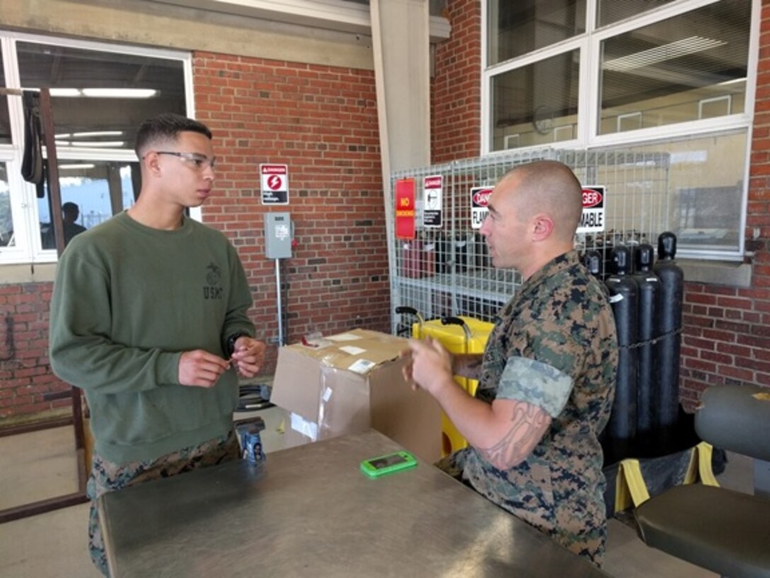 Staff Sergeant Ashley Smith (Right), an instructor with Utilities Instruction Company; explains to Lance Corporal  David Toledo, a Marine from of Los Angeles, CA attached to Basic Refrigeration and Air Conditioning Technician course 3-16 (BRACT 3-16); how to properly flare and bend copper to meet the specifications of the assigned project and fit various diameter connections.
