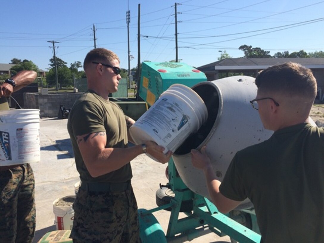On April 26, 2016 Second Lieutenant Thomas Cofer (Left) and First Lieutenant Jonathan Lanning Keller (Right), Marines attached to Combat Engineer Officer course 5-16 (CEO 5-16); load a 9.5 cubic feet concrete mixer with sand. Students are trained how to use locally sourced materials to make their own concrete mix.
