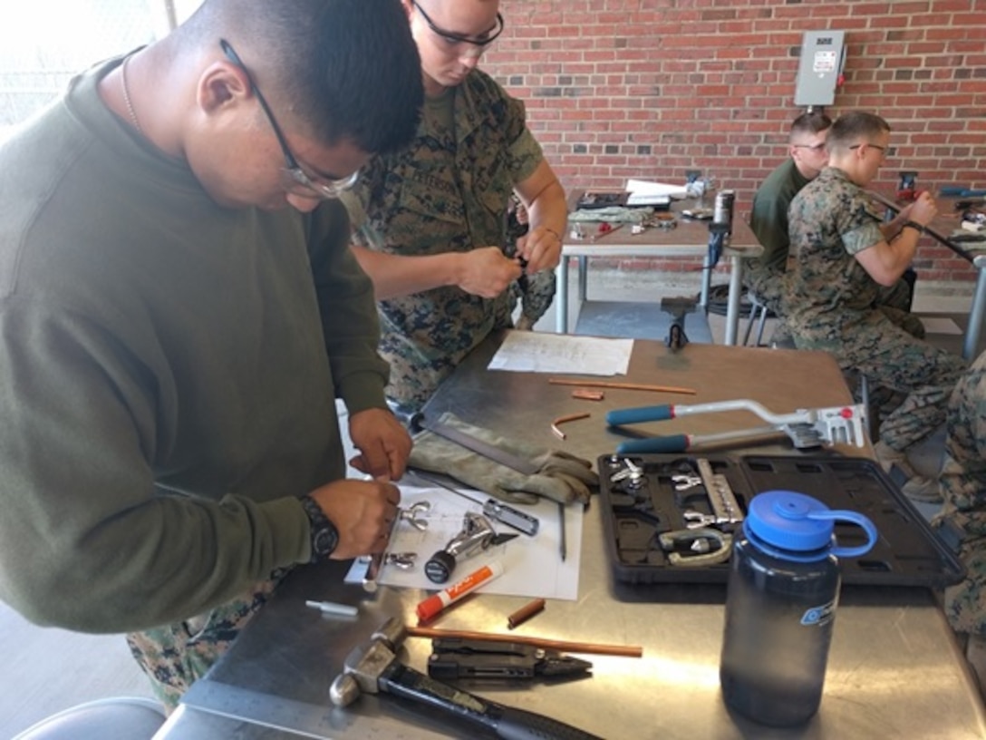 Private First Class Edgar Alcantara from Bronx, NY and Private Kyle Peterson from Athens, AL work on their Leak Proof Connections project that involves combining copper pipe, through the use of flaring and bending the copper; to fit 
various diameters.
