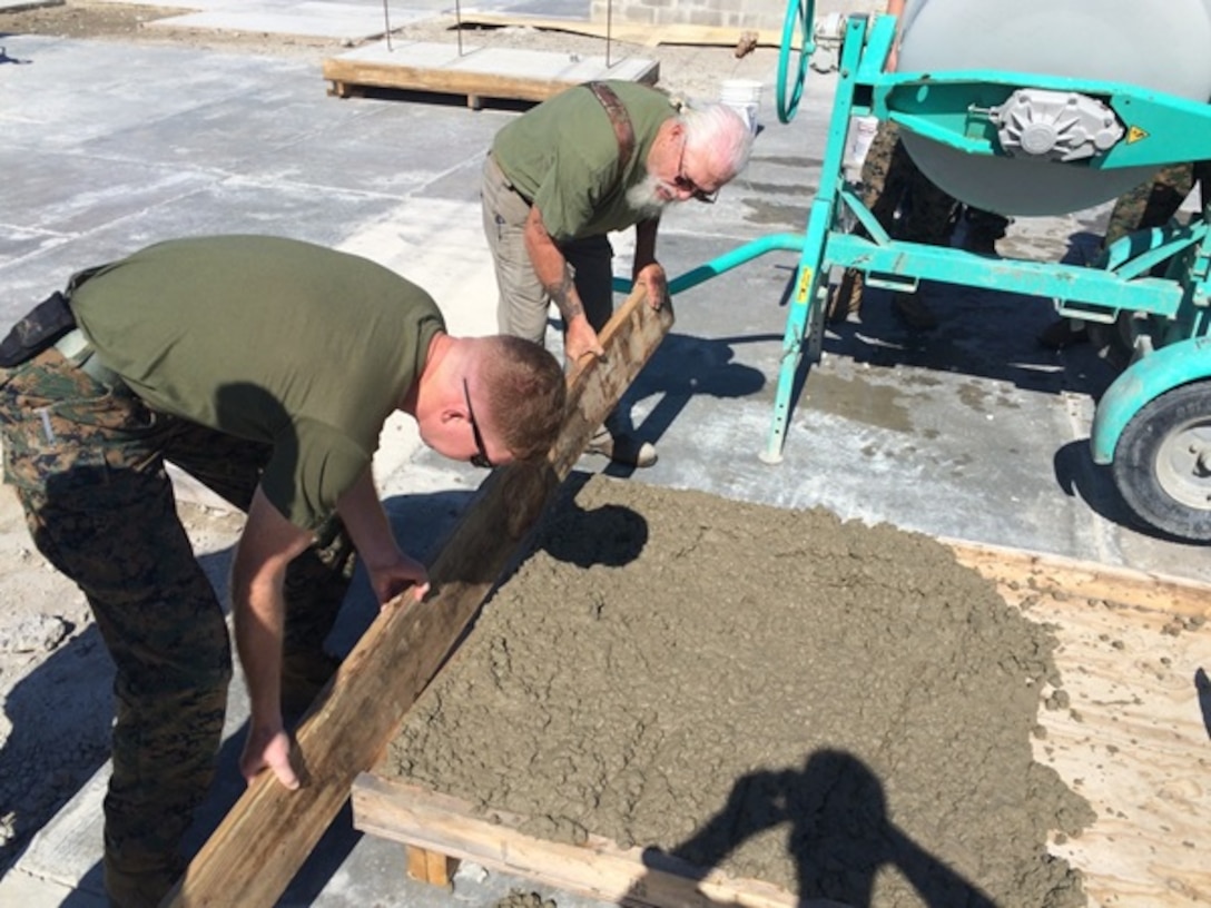 On April 26, 2016 Mr. Ken Harris (right), an instructor with Combat Engineer Instruction Company; levels a concrete pad with Second Lieutenant Nicholas Downey (left), a Marine attached to Combat Engineer Officer course 5-16 (CEO 5-16).  Students use a 2"x6" board to ensure there are no gaps in the concrete.
