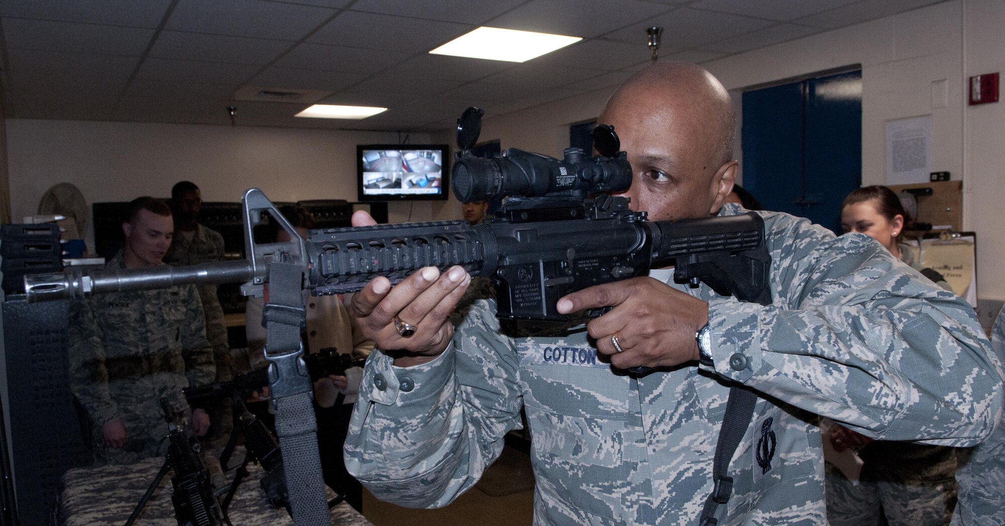 Maj. Gen. Anthony Cotton, 20th Air Force and Task Force 214 commander, looks down the scope of an M-4 rifle, during his tour of the 90th Security Forces Group Armory, April 28, 2016, on F.E. Warren Air Force Base, Wyo. At each stop during Cotton’s visit he asked the Airmen if there was anything they would change if they could; many provided a detailed answer. (U.S. Air Force photo by Airman 1st Class Malcolm Mayfield)