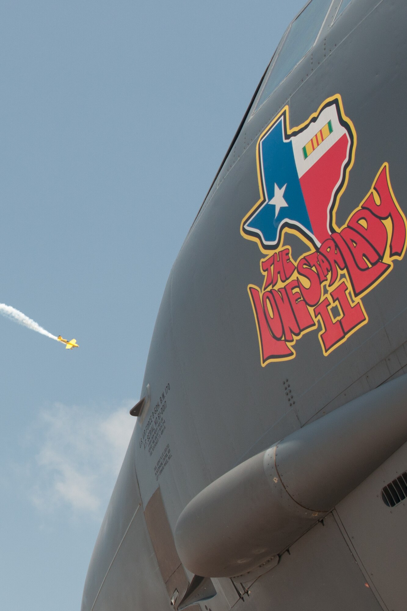 A plane performs aerial acrobatics in front of “The Lone Star Lady II,” a B-52 Stratofortress assigned to the 307th Bomb Wing, during the Barksdale Defenders of Liberty Air Show on Barksdale Air Force Base, La., May 1, 2016. Thousands of spectators travelled to the base to see a wide variety of aircraft on display and in the air. (U.S. Air Force photo by Master Sgt. Dachelle Melville/Released)
