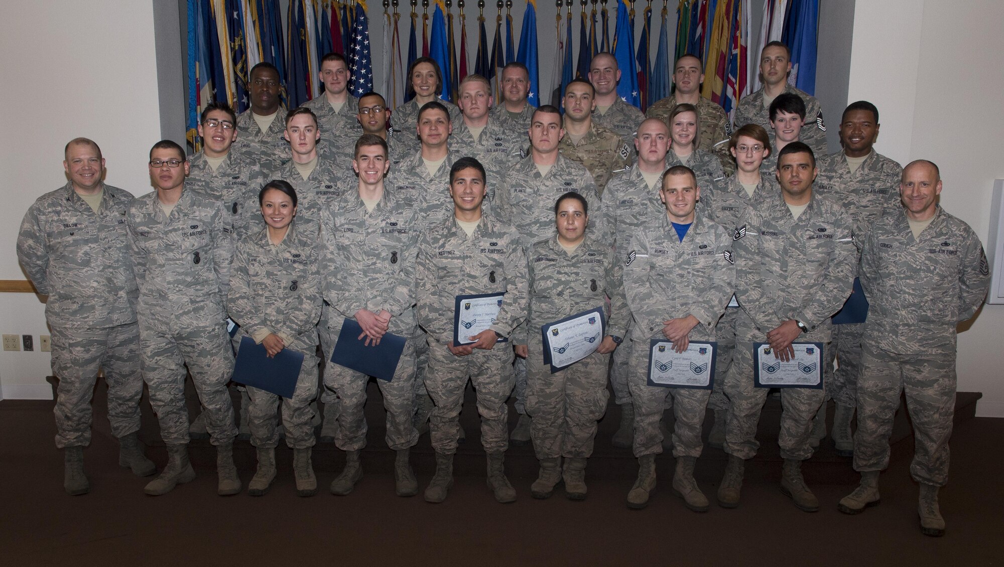 Enlisted F.E. Warren Airmen who promoted in April or put on their new rank May 1 pose for a photo with Col. Matt Dillow, 90th Missile Wing vice commander, and Chief Master Sgt. Samuel Couch, 90th MW command chief, April 29, 2016, in the Trails End Community Center on F.E. Warren Air Force Base, Wyo. Each month the Mighty Ninety hosts a celebration for enlisted promotees from the base. (U.S. Air Force photo by Airman 1st Class Malcolm Mayfield)