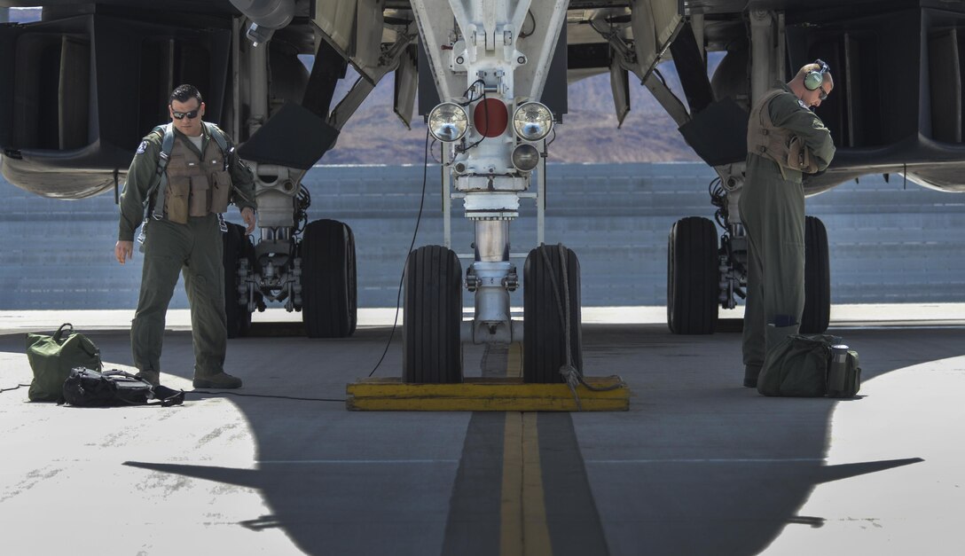 Two aircrew members, assigned to the 34th Bomb Squadron, Ellsworth Air Force Base, South Dakota, load their gear onto a B-1B Lancer before takeoff during Green Flag 16-05 at Nellis Air Force Base, Nev., April 21, 2016. Squadrons, such as the 34th BS, use Green Flag as a valuable opportunity to train new B-1B pilots and crewmembers alike for what to expect downrange. (U.S. Air Force photo by Airman 1st Class Kevin Tanenbaum)