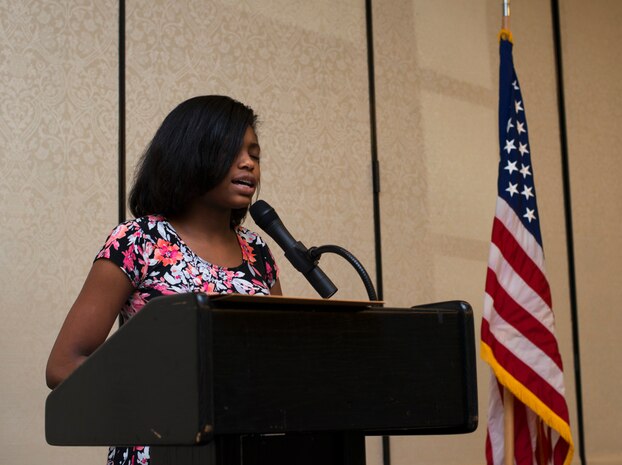 Tiona Smalls, a child from the Joint Base Charleston Community, sings the national anthem at the Child Abuse Prevention Luncheon April 26, 2016  at Joint Base Charleston. During the luncheon, Alana Dodson read a featured poem, The Tiny Child and Simone Edmond introduced the guest speaker. Both Dodson and Edmond were also children from the JB Charleston community. (U.S. Air Force Photo/Airman Megan Munoz)