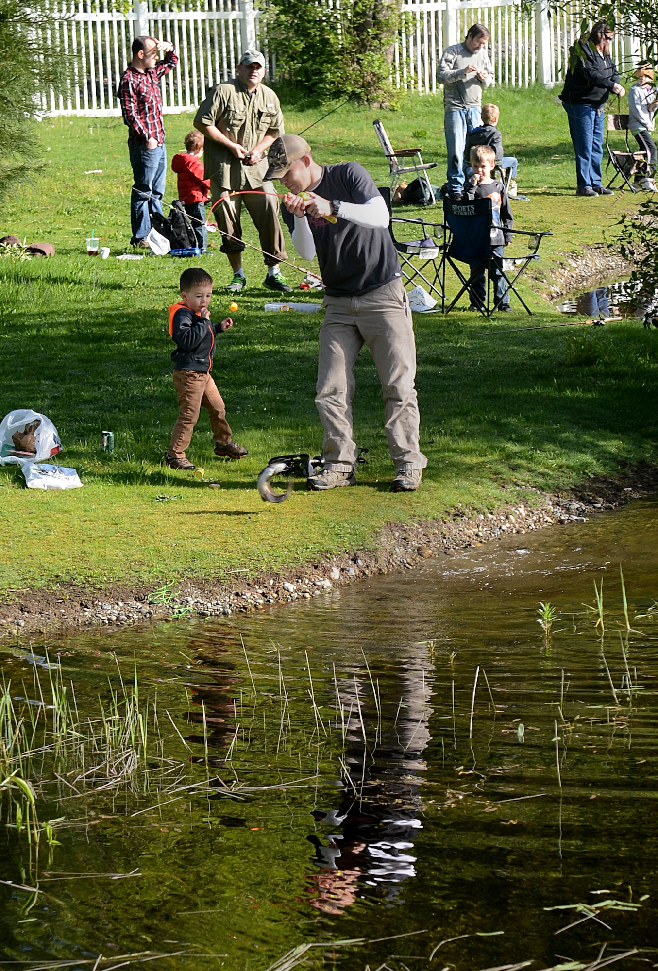 Staff Sgt. Codi Powers, 627th Logistic Readiness Squadron fuels technician, catches a fish with his son during the Annual McChord Field Top III Children’s Fishing Derby April 30, 2016 at Carter Lake on McChord Field, Wash. This was Powers first time attending the fishing derby and he and his son caught multiple fish. (U.S. Air Force photo/Senior Airman Divine Cox)