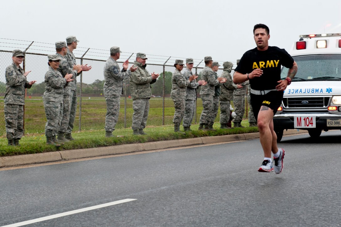 U.S.  Airmen cheer on a U.S. Soldier running in support of the Virginia Run for the Fallen outside the Armistead Gate at Langley Air Force Base, Va., April 28, 2016. The run started at Joint Expeditionary Base Little Creek-Fort Story and is set to end at Arlington National Cemetery, totaling approximately 250 miles in four days. (U.S. Air Force photo by Senior Airman R. Alex Durbin)