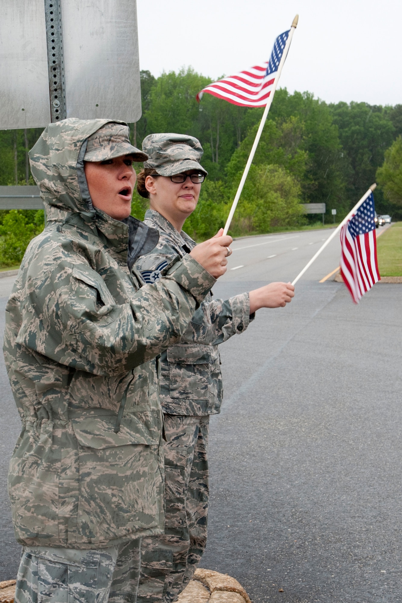 Two U.S. Airmen cheer on runners during the Virginia Run for the Fallen outside the Armistead Gate at Langley Air Force Base, Va., April 28, 2016. Despite inclement weather, Airmen from across Langley gathered to show support for the run as the procession passed the installation. (U.S. Air Force photo by Senior Airman R. Alex Durbin)
