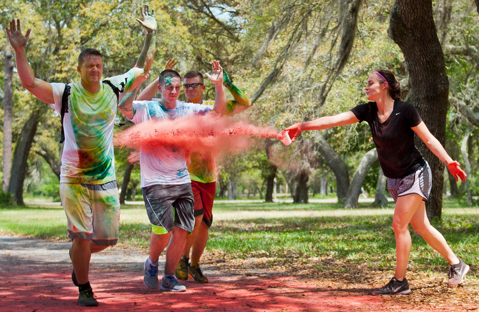 Runners sprint through a cloud of red dust during the Sexual Assault Prevention and Response Color Run at Eglin Air Force Base, Fla., April 29.  Approximately 300 runners turned out to add a little color to their afternoon workout.  (U.S. Air Force photo/Samuel King Jr.)