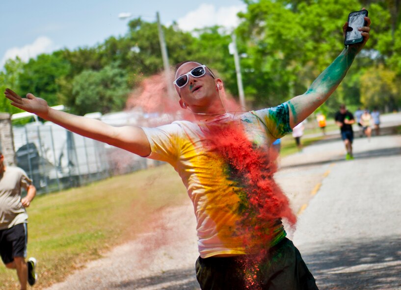 A runner embraces the “Color” as he is hit with a red dust cloud during the Sexual Assault Prevention and Response Color Run at Eglin Air Force Base, Fla., April 29.  Approximately 300 runners turned out to add a little color to their afternoon workout.  (U.S. Air Force photo/Samuel King Jr.)