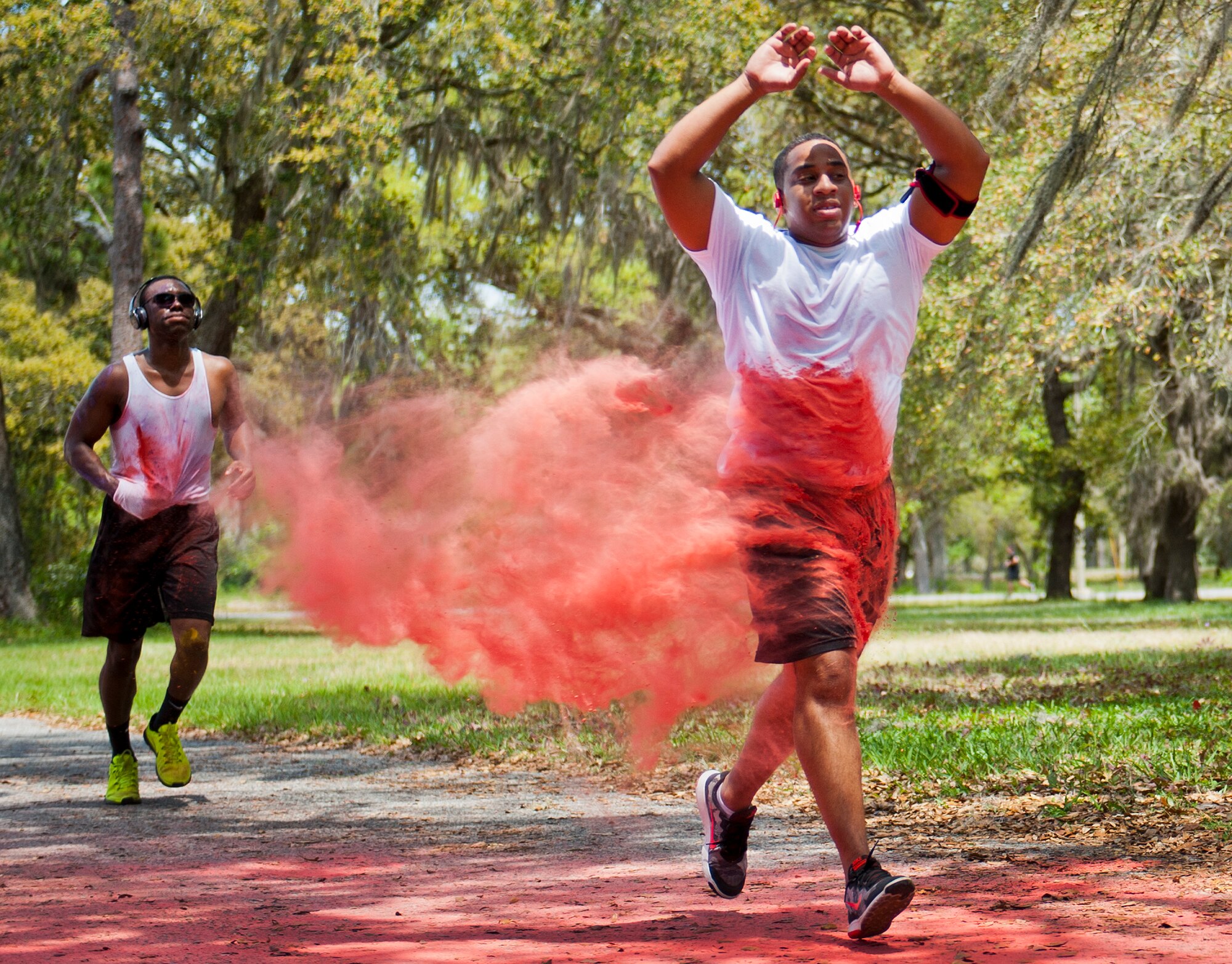 A runner sprints through a cloud of red dust during the Sexual Assault Prevention and Response Color Run at Eglin Air Force Base, Fla., April 29.  Approximately 300 runners turned out to add a little color to their afternoon workout.  (U.S. Air Force photo/Samuel King Jr.)