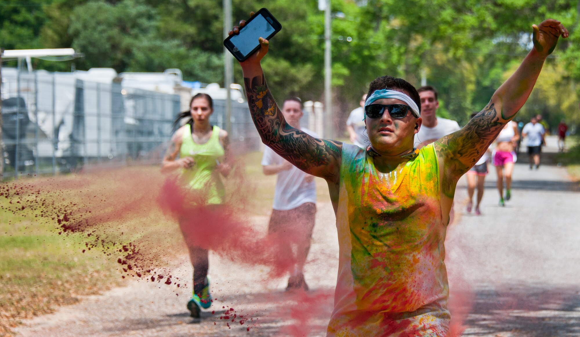 A runner sprints through a cloud of red dust during the Sexual Assault Prevention and Response Color Run at Eglin Air Force Base, Fla., April 29.  Approximately 300 runners turned out to add a little color to their afternoon workout.  (U.S. Air Force photo/Samuel King Jr.)
