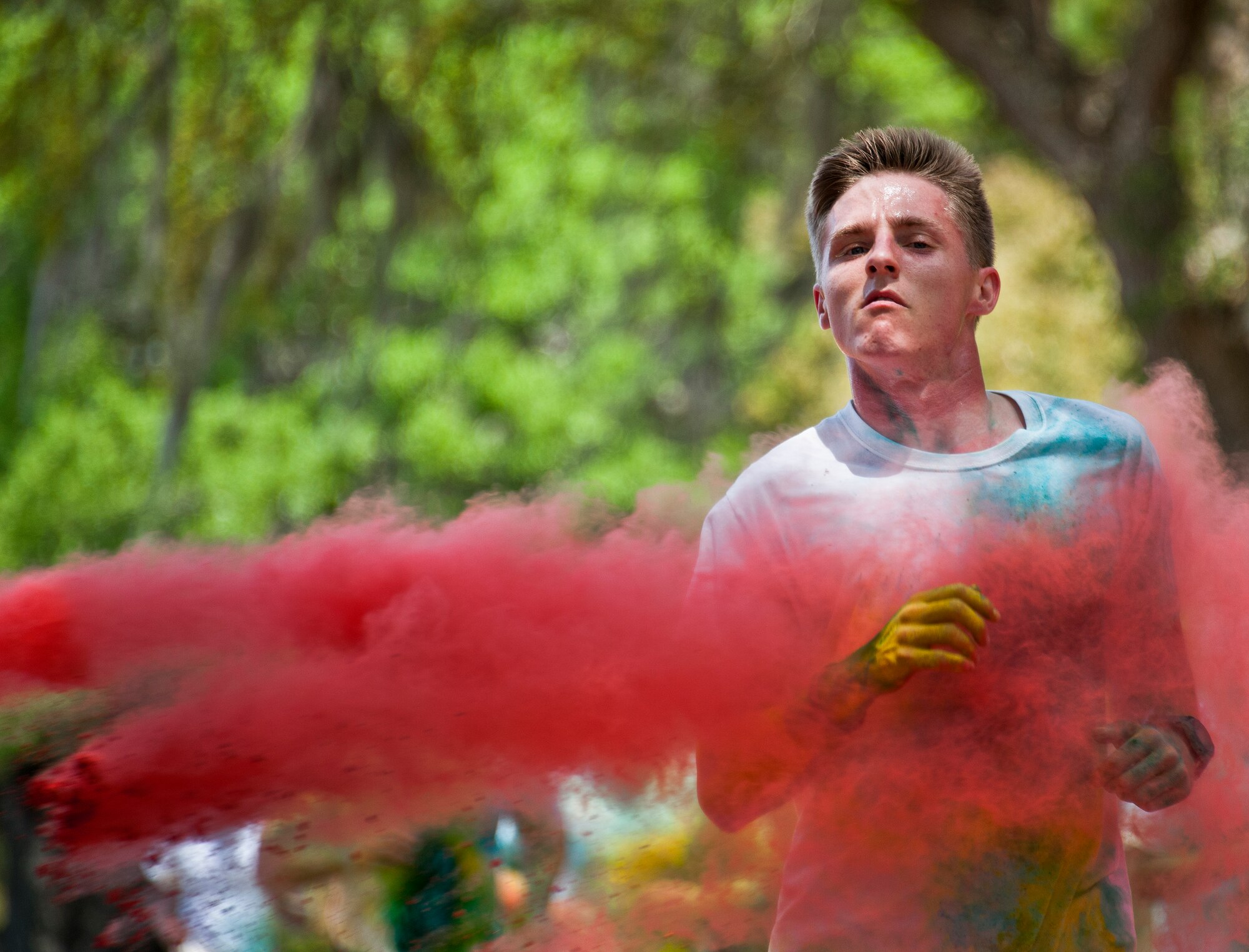 A runner sprints through a cloud of red dust during the Sexual Assault Prevention and Response Color Run at Eglin Air Force Base, Fla., April 29.  Approximately 300 runners turned out to add a little color to their afternoon workout.  (U.S. Air Force photo/Samuel King Jr.)