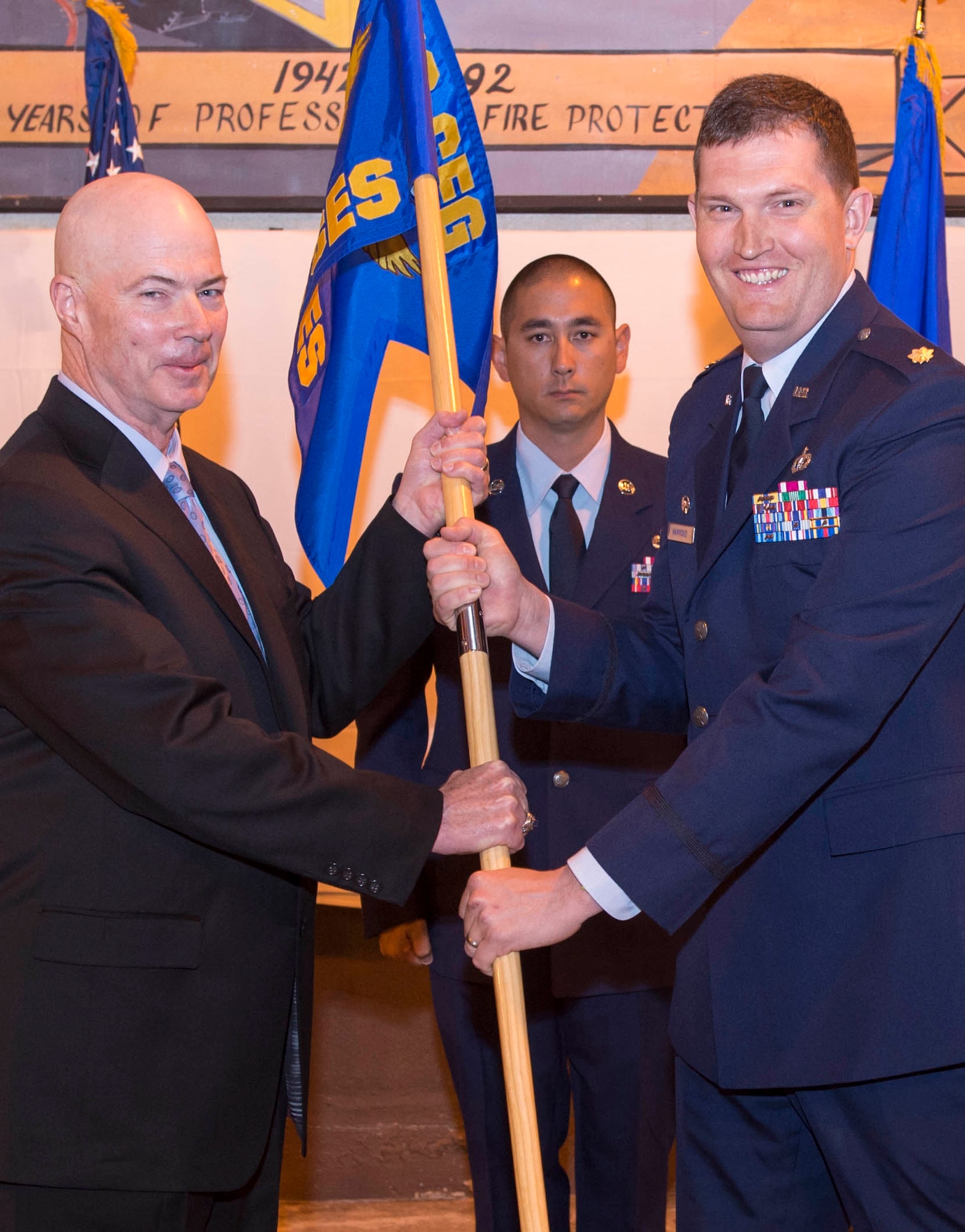 James Judkins, 412th Civil Engineer Group director, passes the command flag to Maj. Gregory Hammond, commander of the 812th Civil Engineer Squadron during the squadron’s stand-up ceremony April 29. Master Sgt. Steven Dale, first sergeant for the 412th Mission Support Group, assists in the ceremony. 
The 812th CES is composed of three flights; Explosive Ordnance Disposal, Fire Department, and Emergency Management.
According to Senior Master Sgt. Brian King, 412th Civil Engineer Group Explosive Ordnance Disposal flight chief, the squadron has actually been in work since October of 2014, when restructuring created the 412th CEG from the former 95th Civil Engineer Group. “You must have squadrons to have a group,” King said.  (U.S. Air Force photo by Christopher Higgins.)
