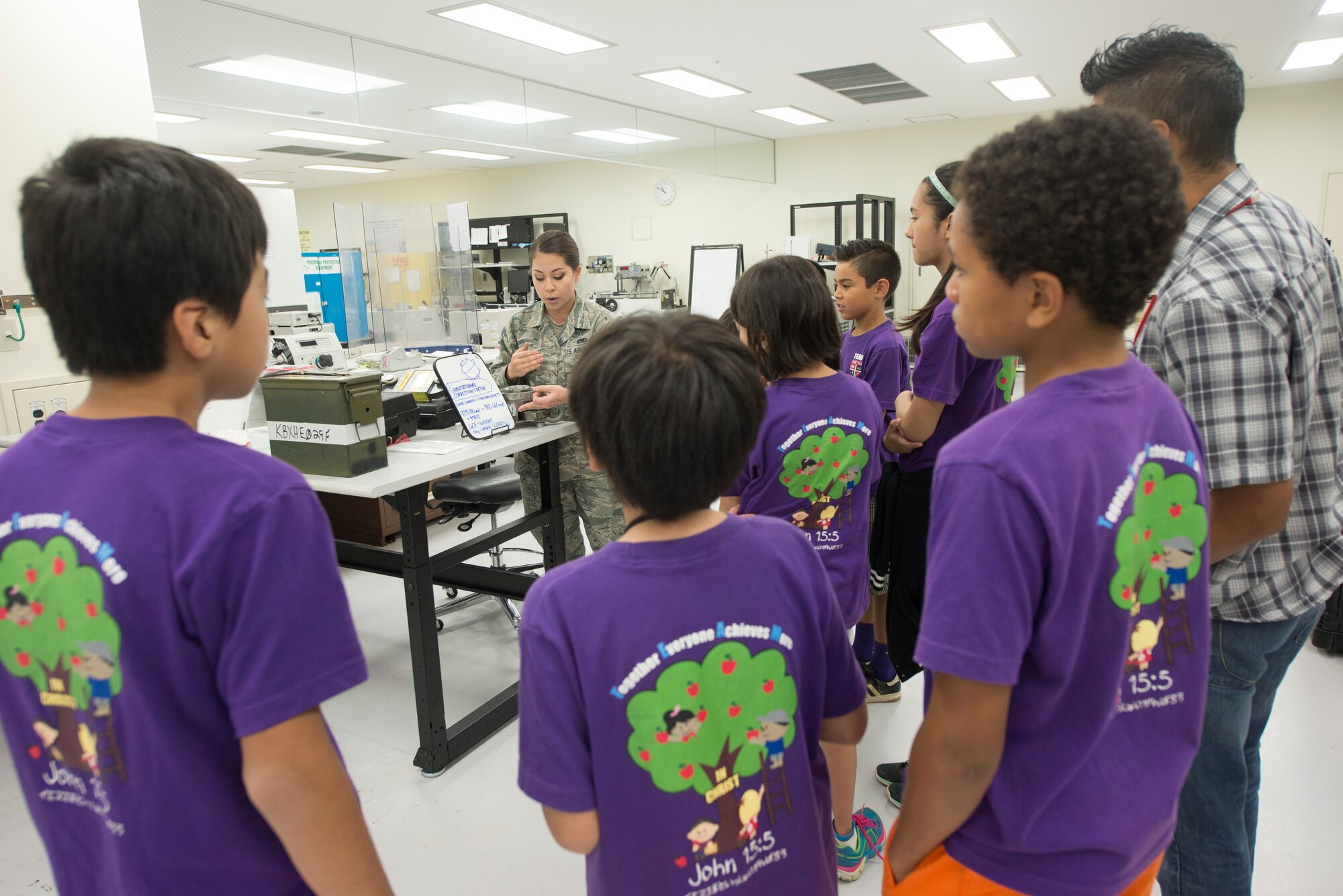 U.S. Air Force Airman 1st Class Amber Lee, 18th Component Maintenance Squadron test measurement and diagnostic equipment technician, teaches Okinawa Christian School International students about the gravitational correction factor April 28, 2016, at Kadena Air Base, Japan. The 18th CMS maintains equipment that measure the center of gravity for aircraft that are critical to take offs and landings. (U.S. Air Force photo by Senior Airman Omari Bernard)