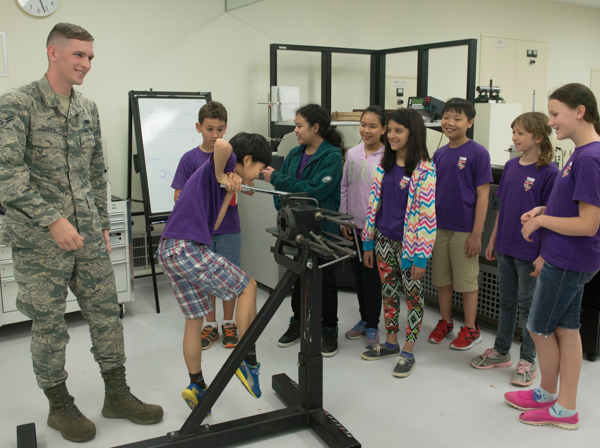 U.S. Air Force Airman 1st Class Stephen Sanders, 18th Component Maintenance Squadron test measurement and diagnostic technicians, explains how torque works to Okinawa Christian School International 5th grade students at the precision measurement equipment laboratory April 28, 2016, at Kadena Air Base, Japan. The 18th CMS demonstrated how physics are applied to everyday procedures in the U.S. Air Force. (U.S. Air Force photo by Senior Airman Omari Bernard)