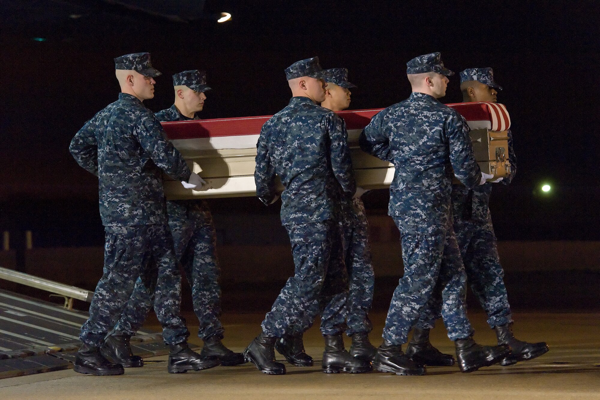 A U.S. Navy carry team transfers the remains of Navy civilian Michael M. Baptiste, of Brooklyn, N.Y., during a dignified transfer May 1, 2016, at New Castle Air National Guard Base, New Castle, Del. Mr. Baptiste was assigned to Forward Deployed Regional Maintenance Center Detachment Bahrain at Naval Support Activity Bahrain. (U.S. Air Force photo/Roland Balik)