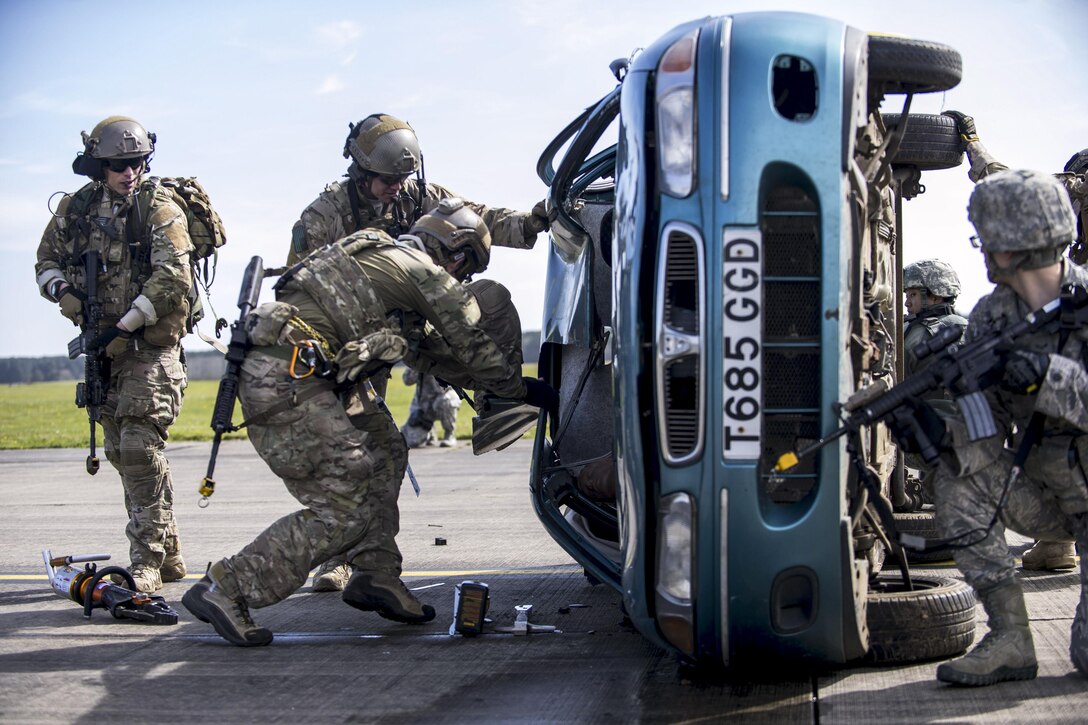 Airmen use the Jaws of Life to tear apart a vehicle's roof to remove a mock victim as part of a combat search-and-rescue demonstration during a civic leader program at Royal Air Force Lakenheath, England, April 21, 2016. The airmen are assigned to the 57th Rescue Squadron. Air Force photo by Staff Sgt. Emerson Nunez
