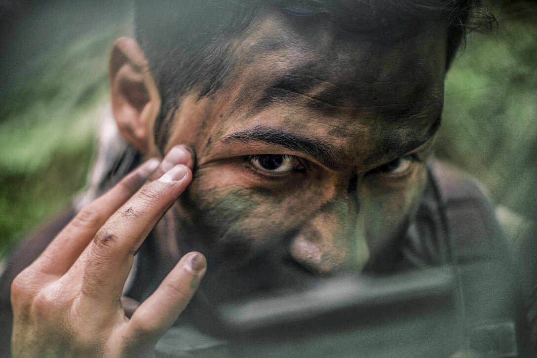 Air Force Capt. Daniel Stancin applies face paint during survival, evasion, resistance and escape training at Yokota Air Base, Japan, April 21, 2016. The training keeps personnel prepared for contingency situations such as evading and escaping capture behind enemy lines. Stancin is a navigator assigned to the 36th Airlift Squadron. Air Force photo by Senior Airman Delano Scott