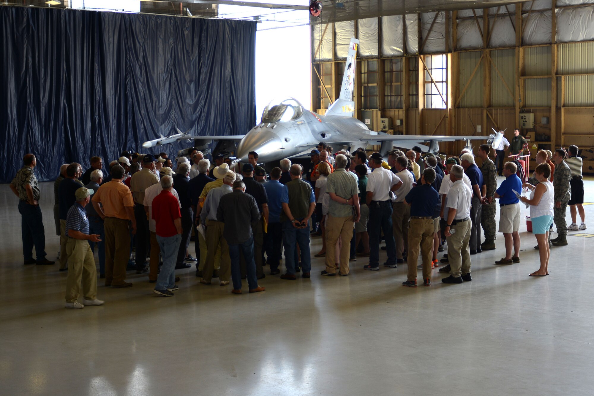 Visitors gather around an F-16CM Fighting Falcon as U.S. Air Force Maj. Matthew Feeman, 20th Operations Support Squadron wing weapons, describes its parts and function at Shaw Air Force Base, S.C., April 29, 2016. The static F-16 display was the last stop of the tour before the event came to a close. (U.S. Air Force photo by Airman 1st Class Kelsey Tucker)