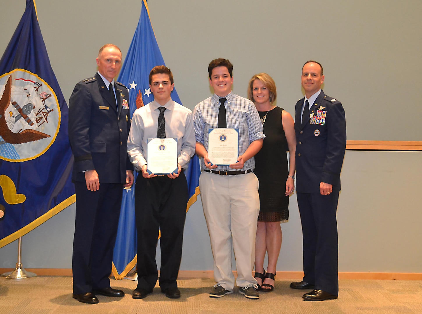 During a retirement ceremony for Air Force Col. Patrick Owens (far right), DLA Troop Support Clothing and Textiles director, Air Force Lt. Gen. William J. Bender, Office of the Secretary of the Air Force chief of information dominance and chief information officer (left) presents Owens’ two sons with letters of appreciation. Owens’ wife is also pictured. Owens retired after a 30-year career and two years as the C&T director.