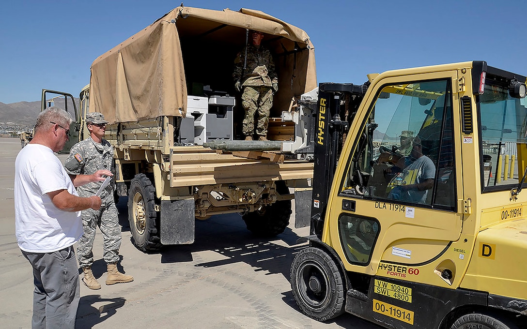 Ray Menendez (left), a DLA Disposition Services material examiner helps units at Fort Bliss, Texas, turn in excess property as part of "All Army Divestiture." Photo by Jeff Landenberger